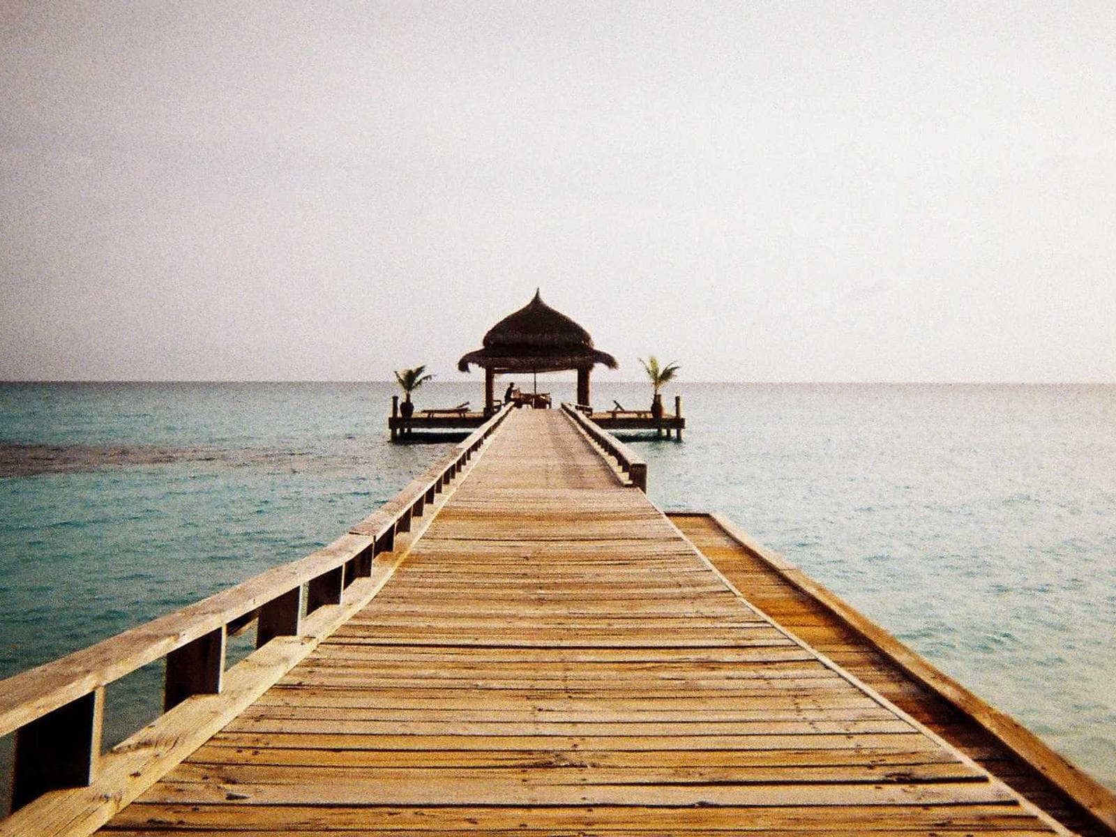 Pontile di legno verso un piccolo padiglione sul mare